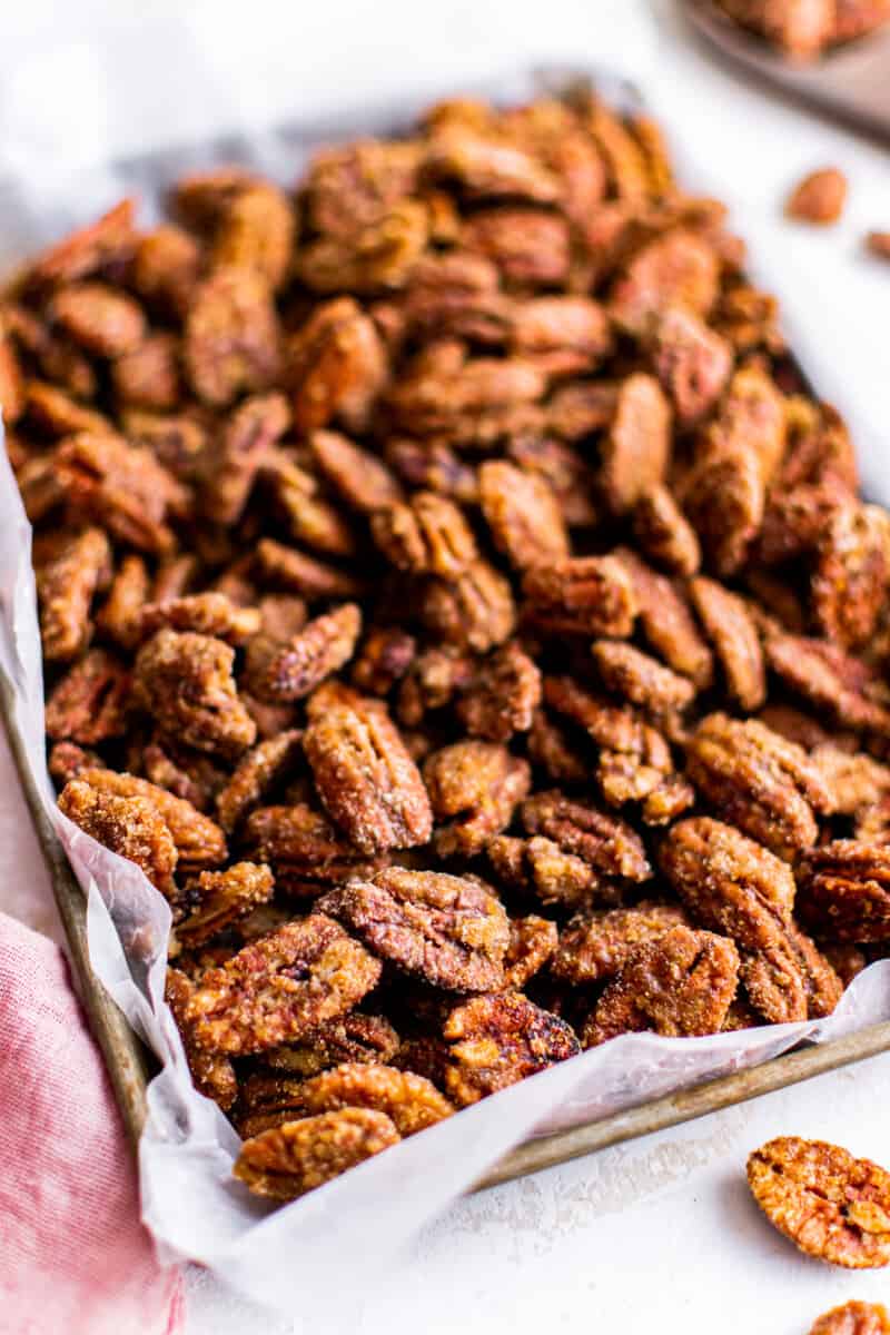 candied pecans on a parchment paper lined baking sheet