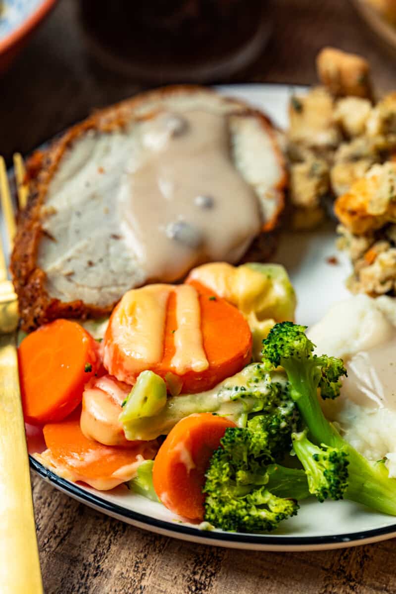 plate with thanksgiving sides and cheesy roasted vegetables