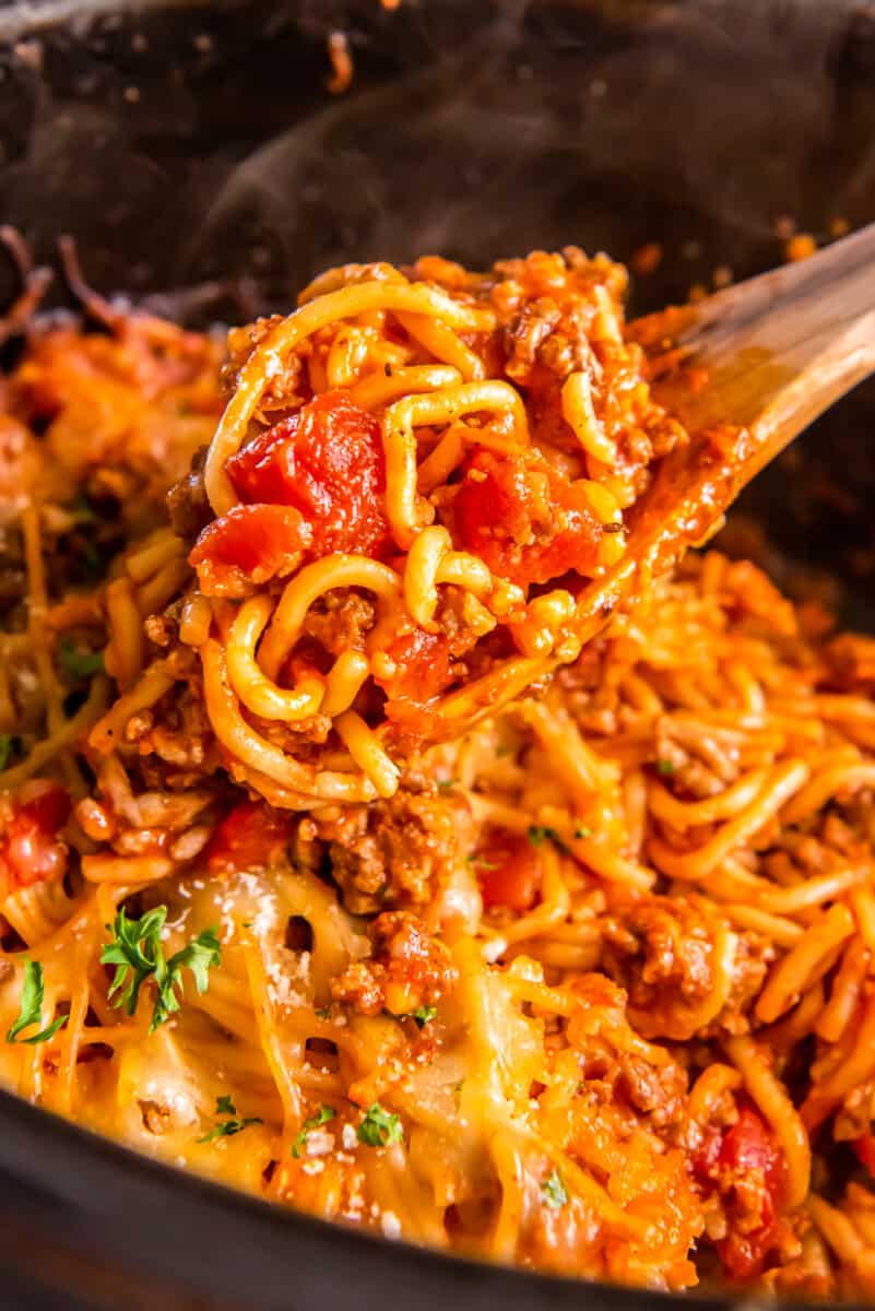 wooden spoon in crock pot with spaghetti casserole