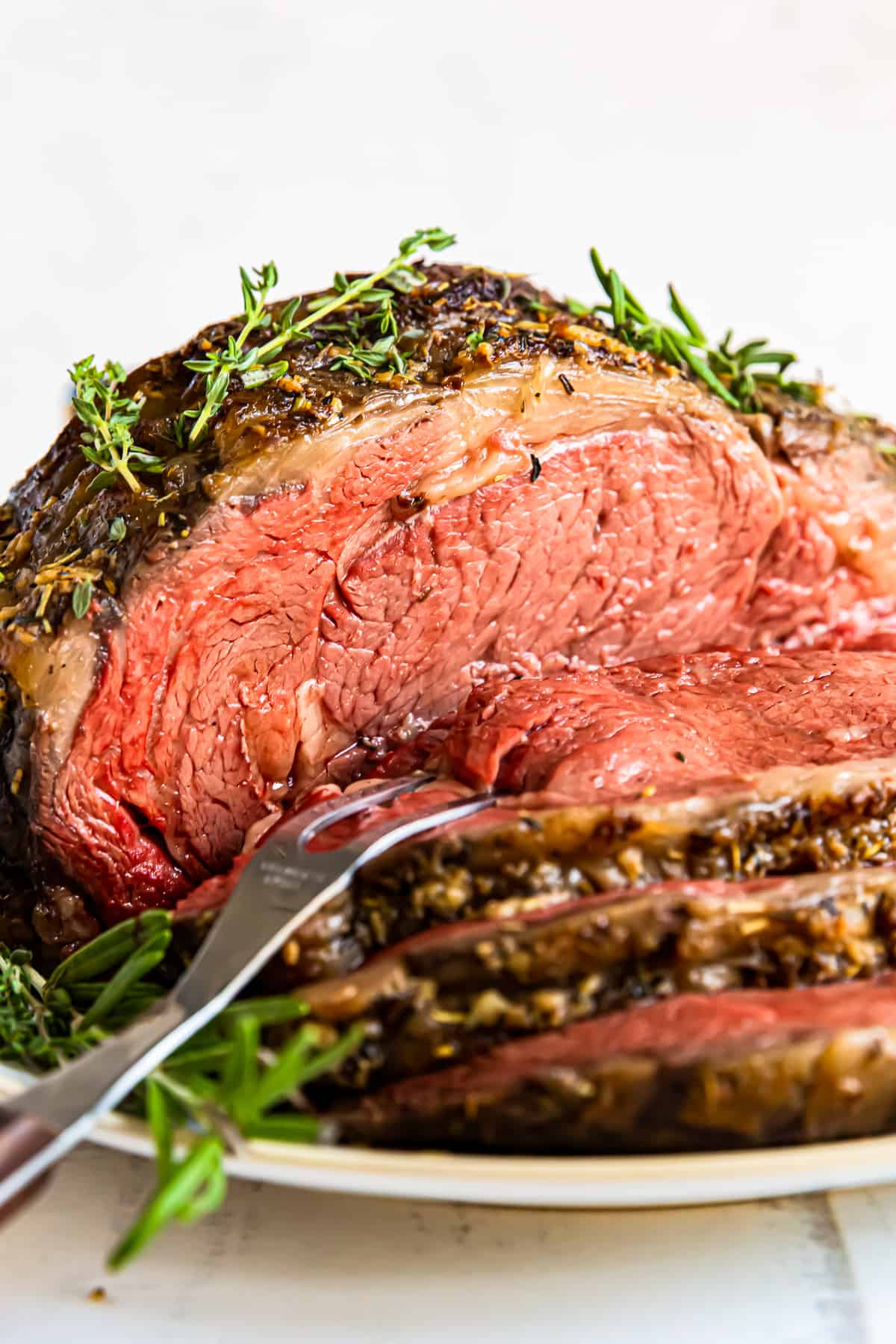 sliced garlic butter prime rib with a serving fork