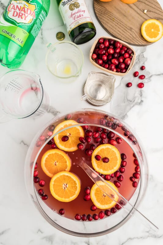 overhead image of holiday punch in a glass bowl with orange slices and cranberries