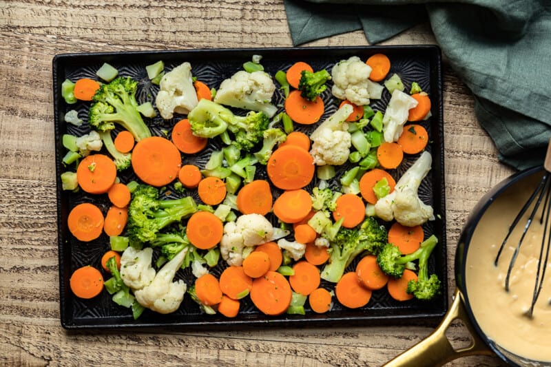 a tray with carrots, broccoli and cauliflower on it.