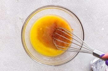 melted butter and buffalo sauce with a whisk in a glass bowl