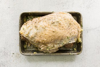 turkey breast coated in olive oil and seasoning on a baking sheet