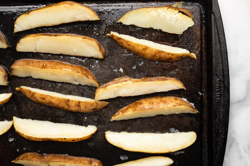 potato wedges on a baking sheet before baking