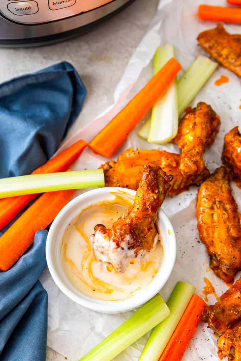 buffalo chicken wing placed in a bowl of dressing
