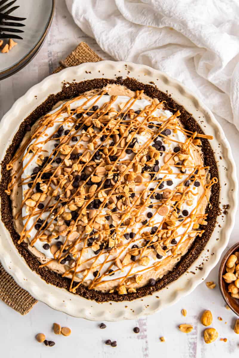 overhead image of peanut butter pie topped with whipped cream, melted peanut butter, chocolate chips, and peanut butter chips