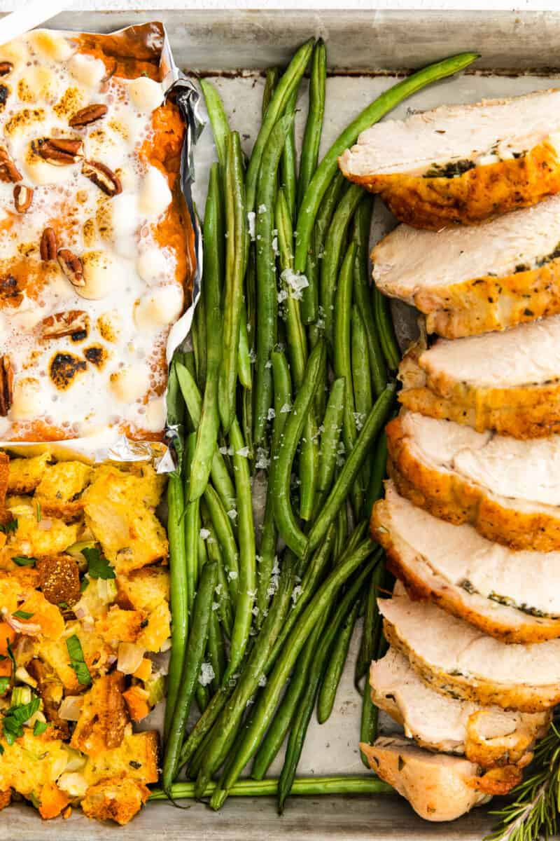 4 parts of sheet pan thanksgiving including sweet potato casserole, dressing, green beans, and turkey breast