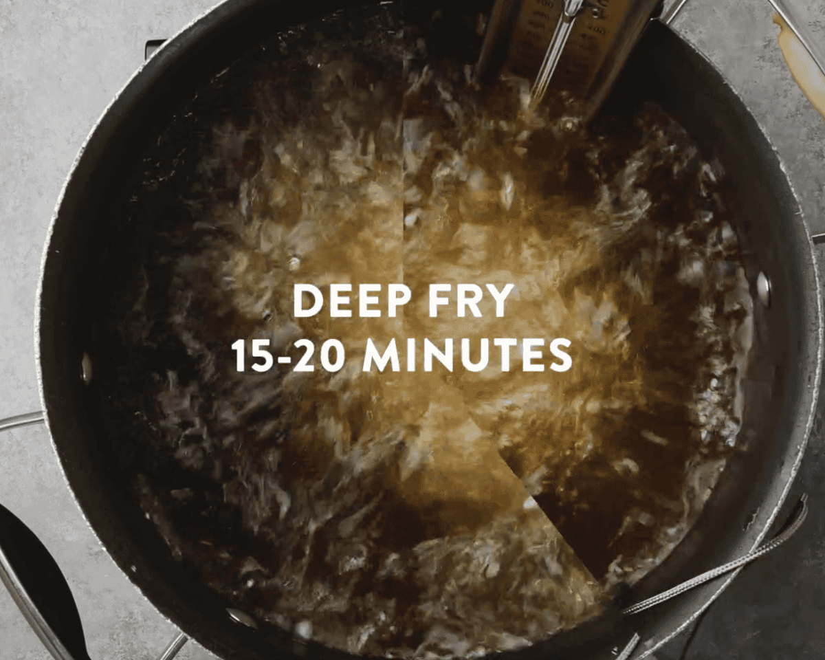 Turkey breast frying in bubbling hot oil inside a deep pot