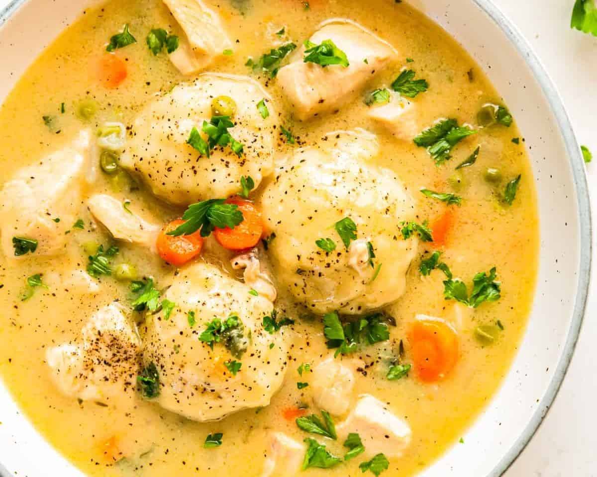 Bowl of chicken and dumpling soup garnished with parsley.  - 14