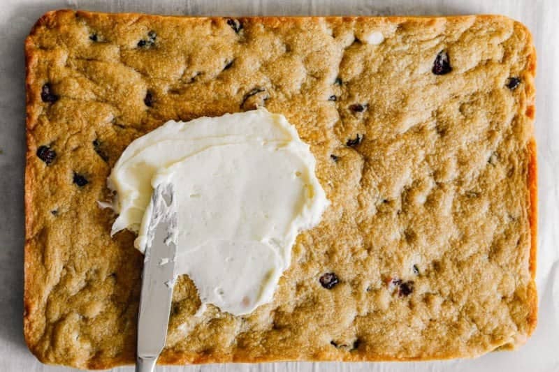 Spreading the cream cheese frosting over the bars. 