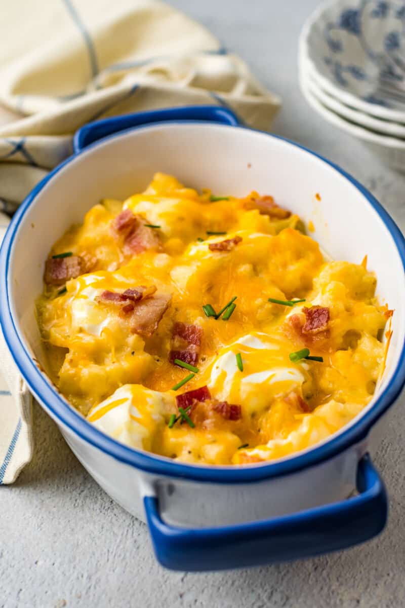 loaded cauliflower bake in a blue and white casserole dish.