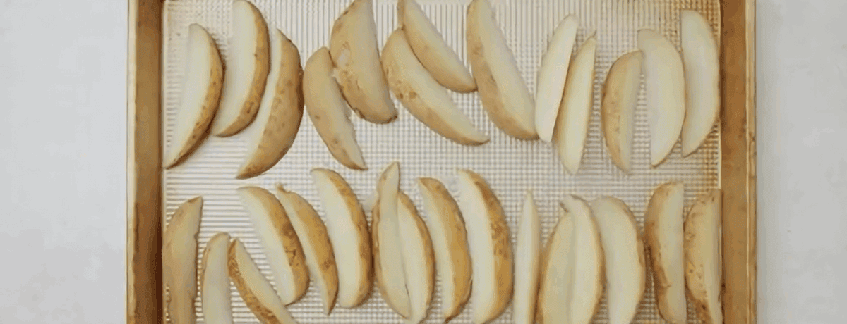Potato wedges on a cookie sheet. 