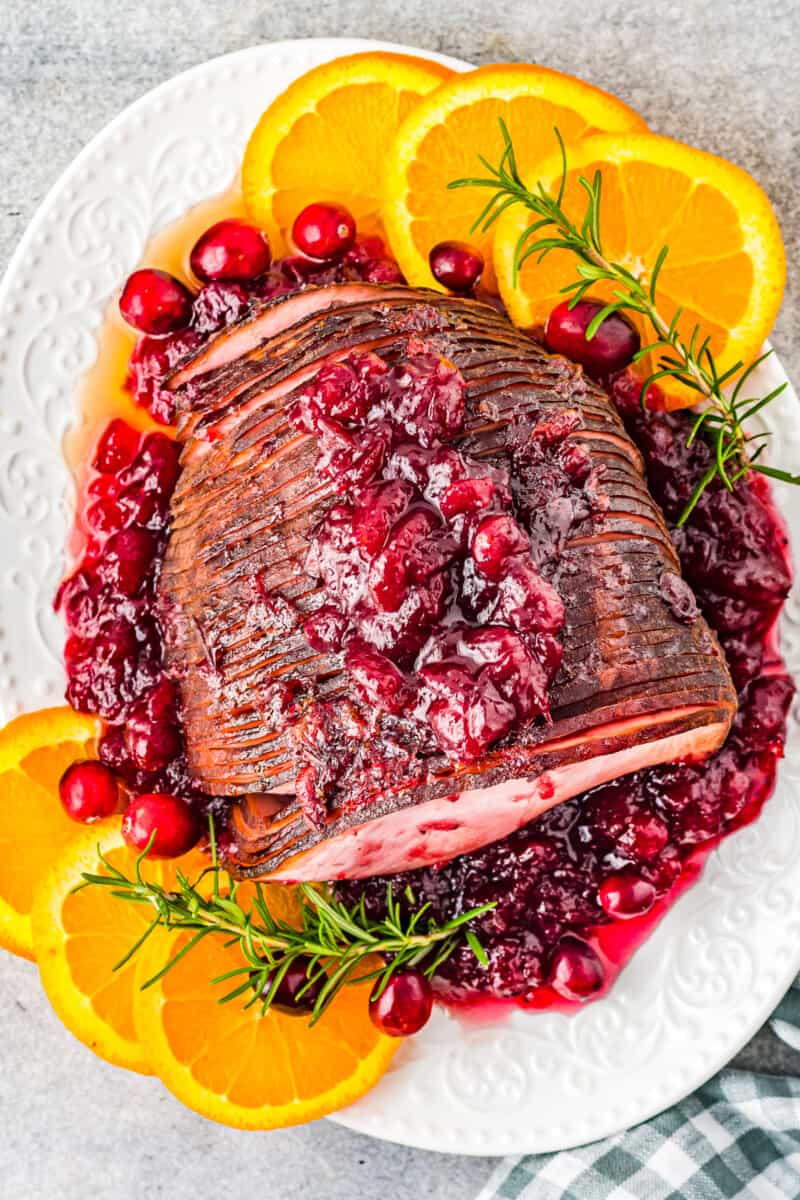 overhead image of cranberry glazed ham on a white serving platter