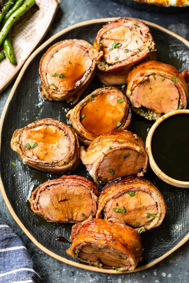 slices of bacon wrapped pork tenderloin on a serving plate