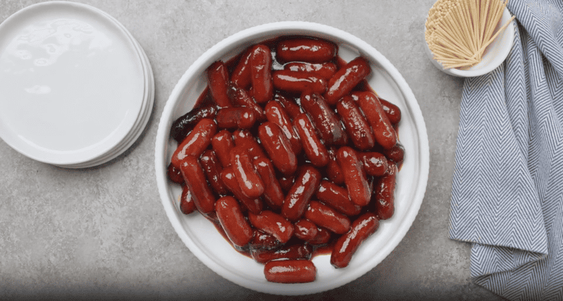 Chinese crockpot little smokies in a white bowl on a table.