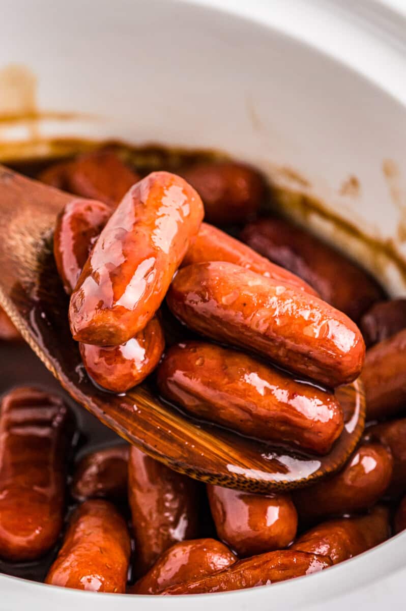 wooden spoon in a crockpot with little smokies