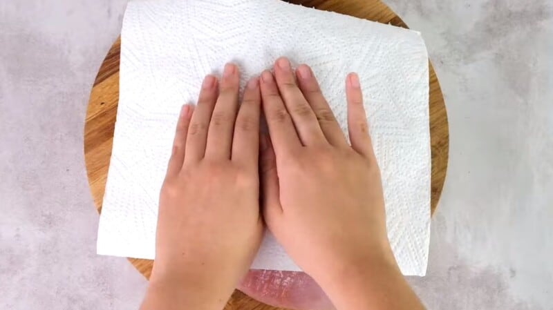 hands drying turkey breast with paper towels