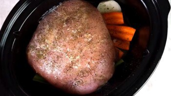 seasoned turkey breast and vegetables inside of a crock pot