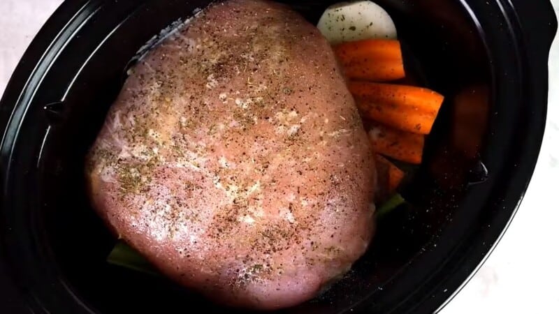 seasoned turkey breast and vegetables inside of a crock pot