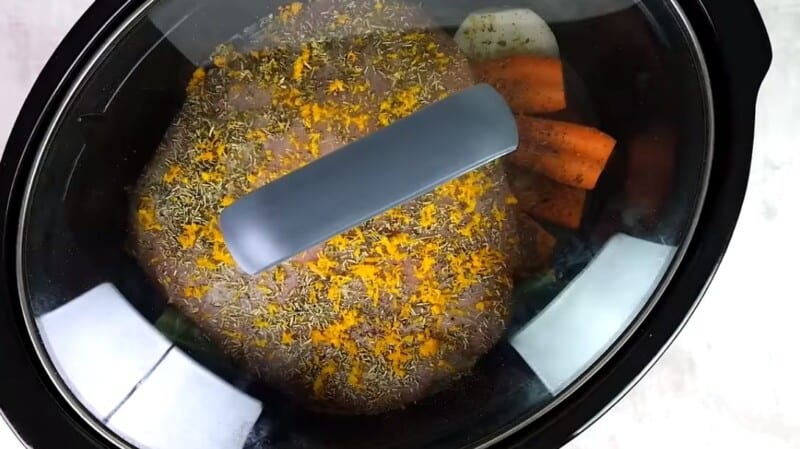 crock pot with a lid, turkey and vegetables inside