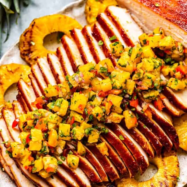 sliced huli huli turkey breast topped with pineapple salsa on a serving platter