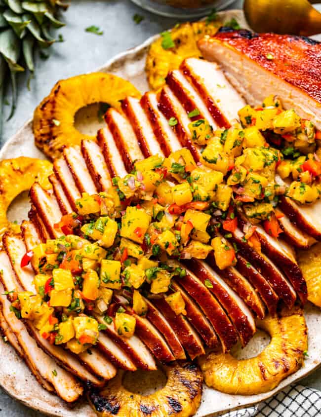 sliced huli huli turkey breast topped with pineapple salsa on a serving platter