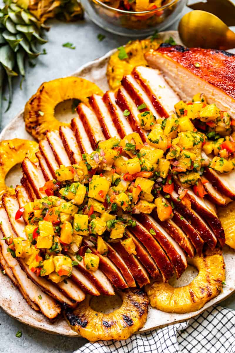 sliced huli huli turkey breast topped with pineapple salsa on a serving platter