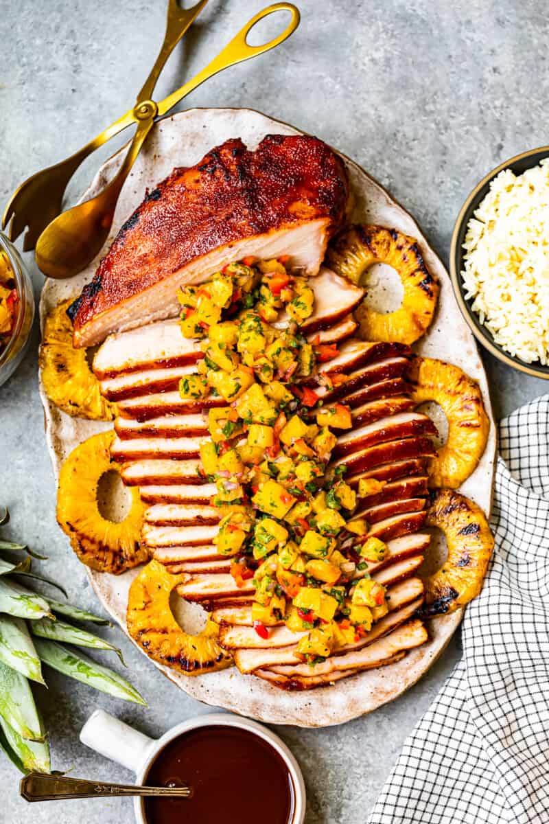 sliced huli huli turkey breast topped with pineapple salsa on a serving platter