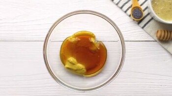 mixing honey and dijon mustard in a glass bowl