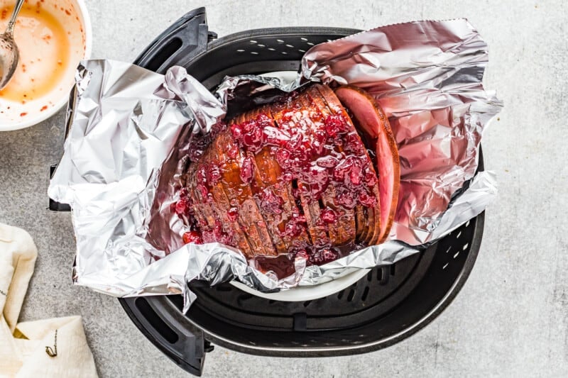 ham on foil topped with cranberry sauce in the air fryer