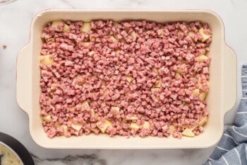 diced ham on top of potatoes in casserole dish