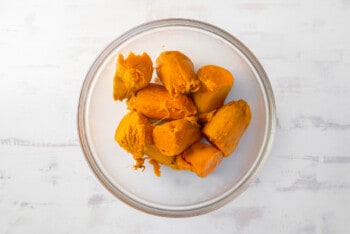 cooked sweet potato halves in a glass bowl