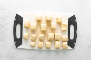 parker house rolls dough rolled out on a cutting board and cut into squares before baking