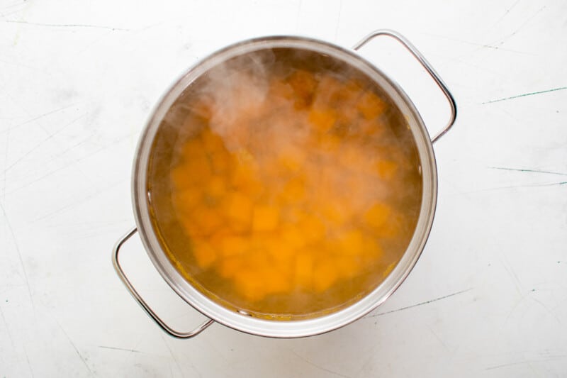 cubed sweet potatoes boiling in a pot of water