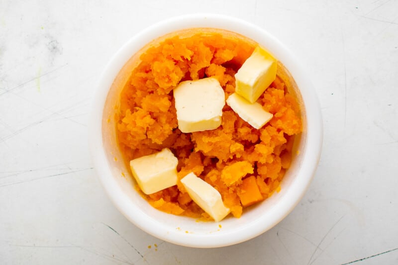 mashed sweet potatoes and butter in a white bowl