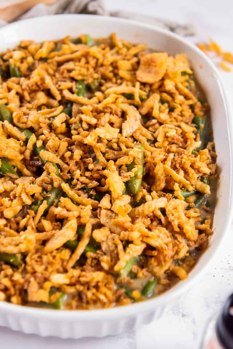 green bean casserole topped with fried onions in a white casserole dish