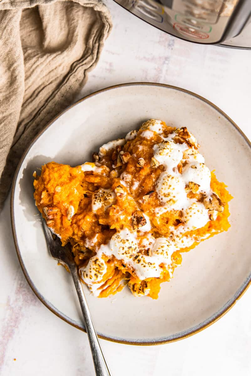 serving of sweet potato casserole on a white plate with a fork