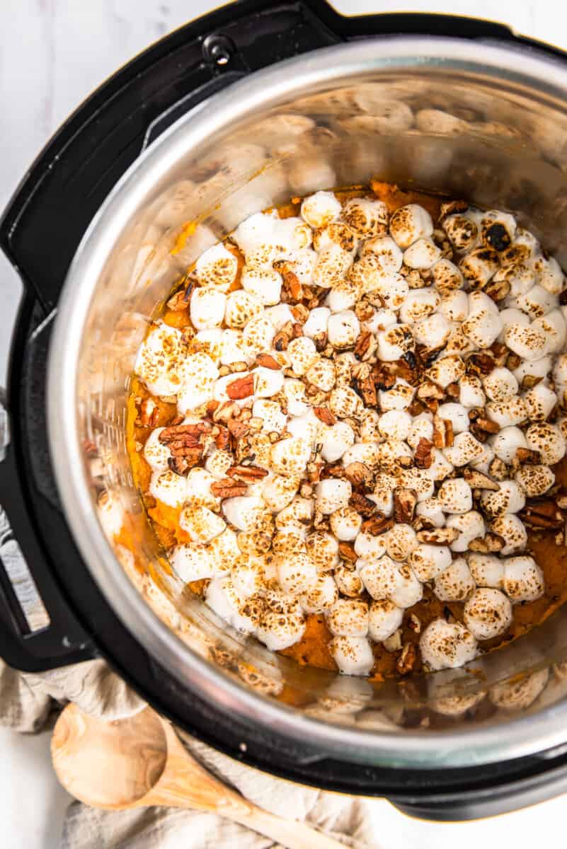overhead image of sweet potato casserole in instant pot topped with marshmallows and pecans