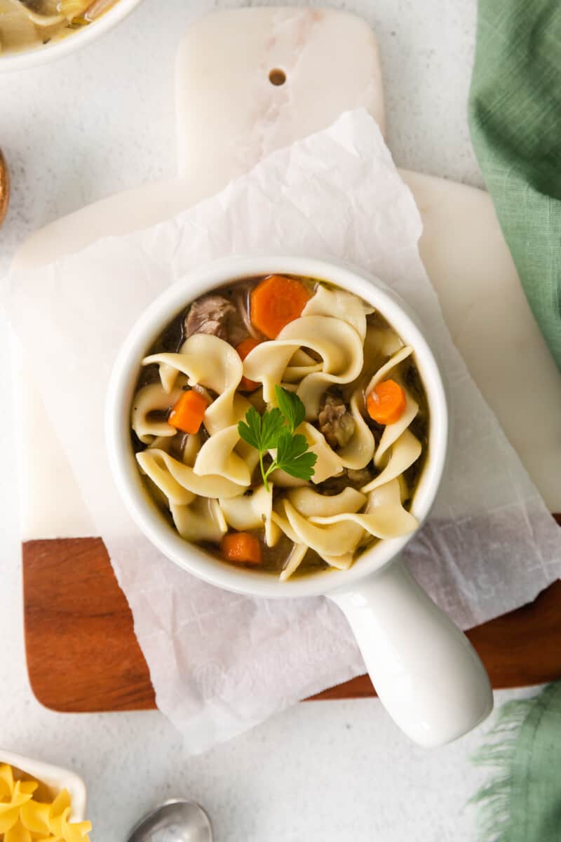 overhead image of turkey noodle soup in a white bowl