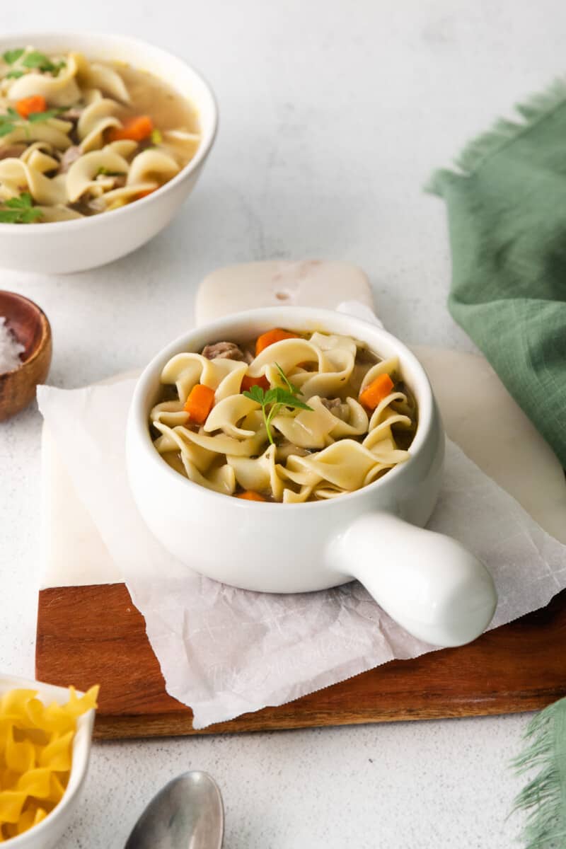 turkey noodle soup in a white bowl