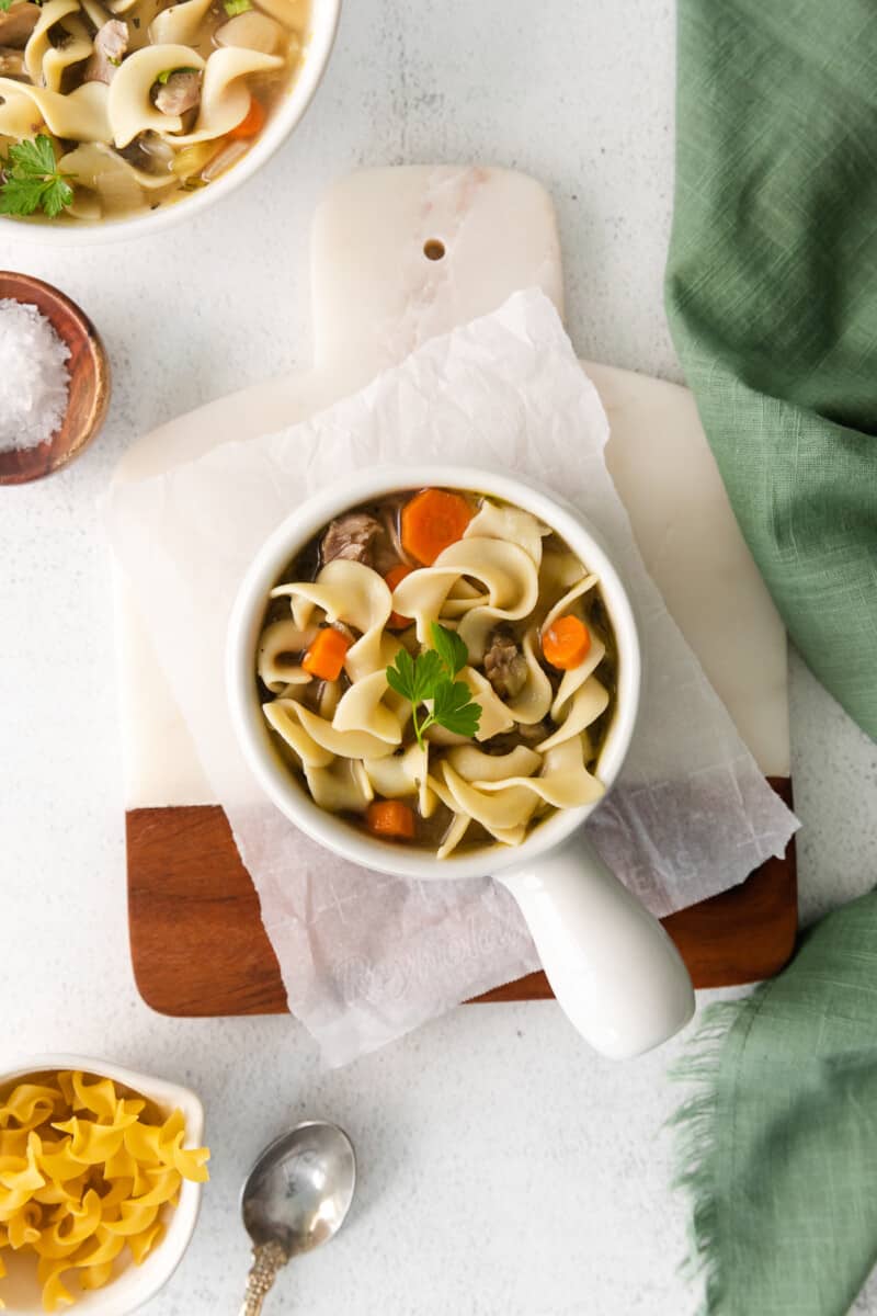 overhead image of turkey noodle soup in a white bowl