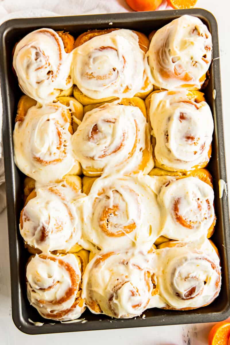 frosted orange rolls in baking dish