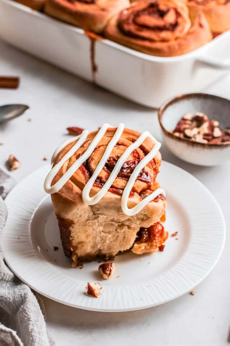 pecan caramel roll on a plate drizzled with icing