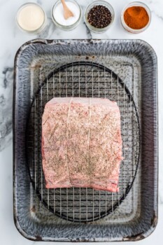 prime rib covered with seasonings on a baking pan