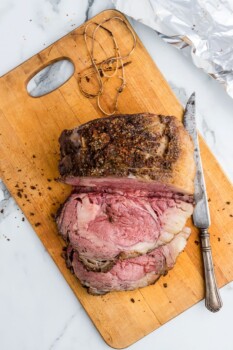 prime rib roast on a cutting board, partially sliced