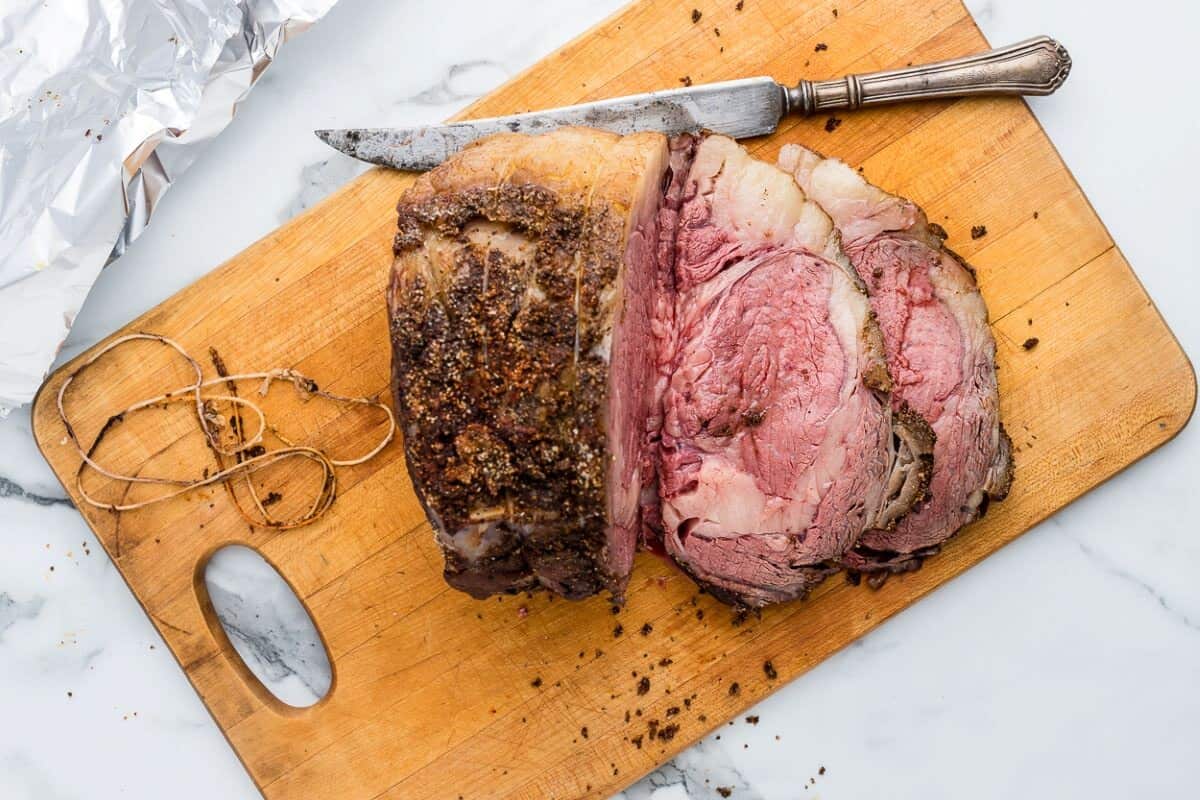 prime rib roast on a cutting board, partially sliced