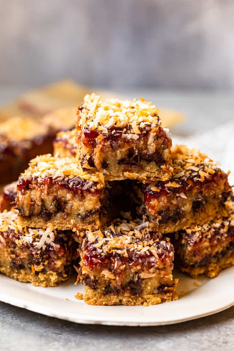 stack of raspberry chocolate coconut bars on a white serving plate