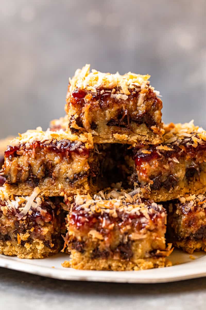 stack of raspberry chocolate coconut bars on a white serving plate