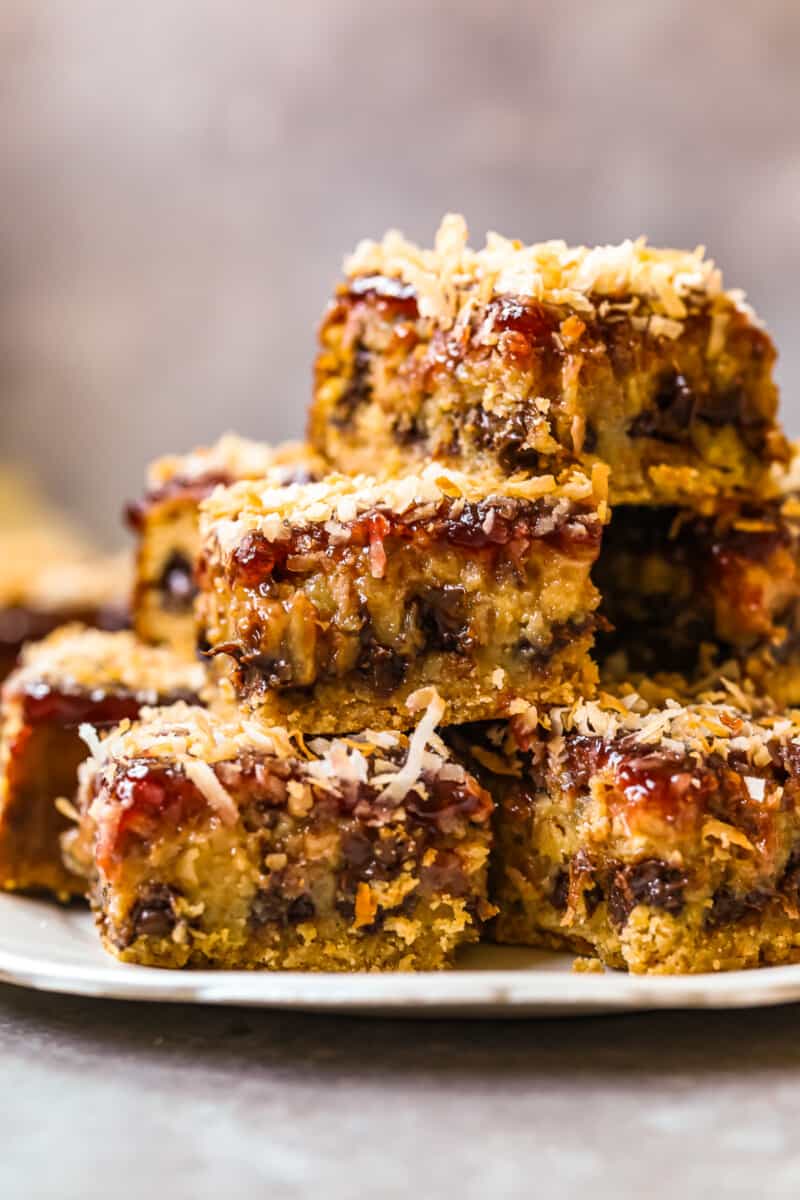 stack of raspberry chocolate coconut bars on a white serving plate